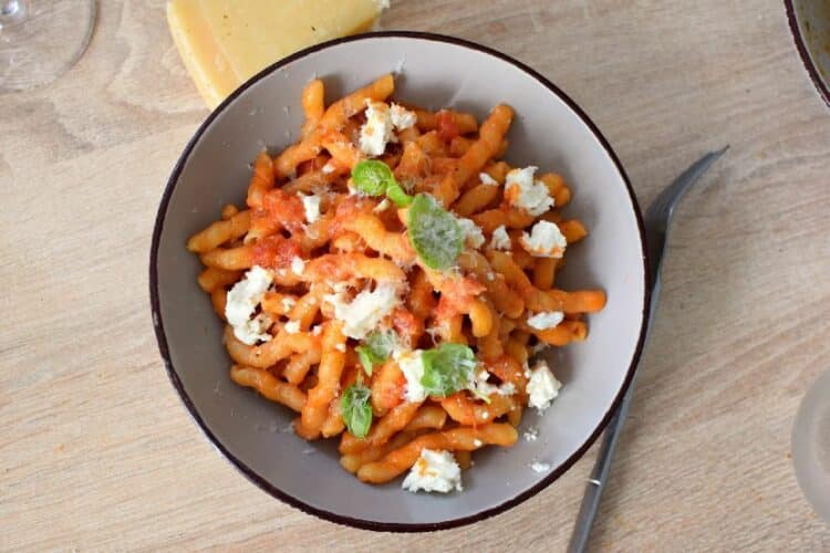 un plat de pâtes à la ricotta et à la tomate avec une sauce crémeuse et du basilic frais