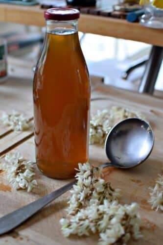 Un bouteille remplie de sirop infusé aux fleurs d'acacia