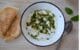 un bol blanc contenant du labné, fromage libanais, à la feta et arrosé d'une huile parfumée à la menthe