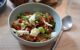 Une assiette creuse contenant une salade tomate mozarella au pesto de basilic