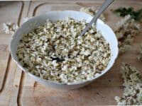 Un bol rempli de sirop dans lequel infusent des fleurs d'acacia