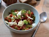 Une assiette creuse contenant une salade tomate mozarella au pesto de basilic